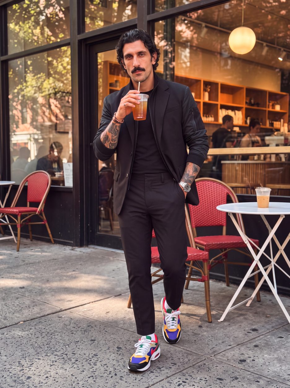The suit styled down with sneakers outside a cafe