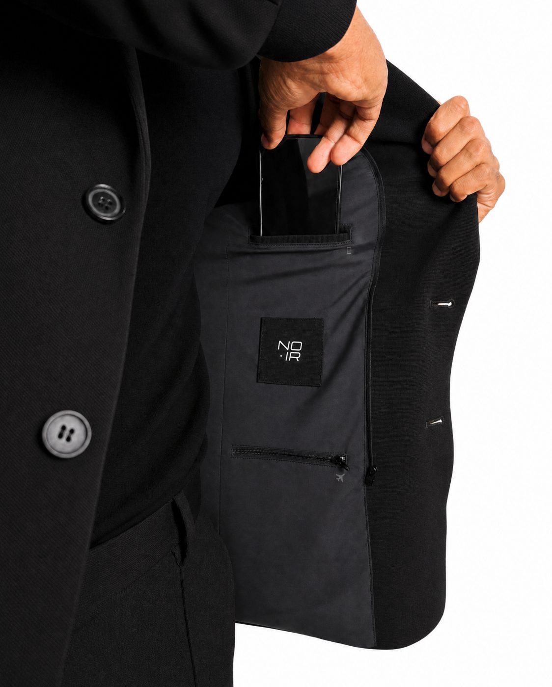 A phone sliding into the concealed interior pocket while worn