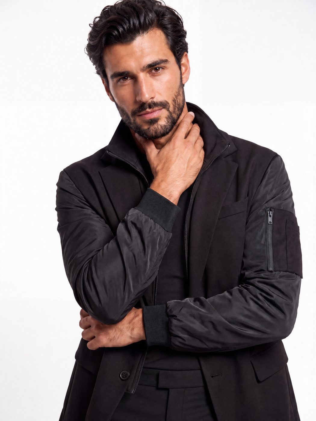 Studio portrait showing the bomber sleeve and arm zip pocket of the signature blazer