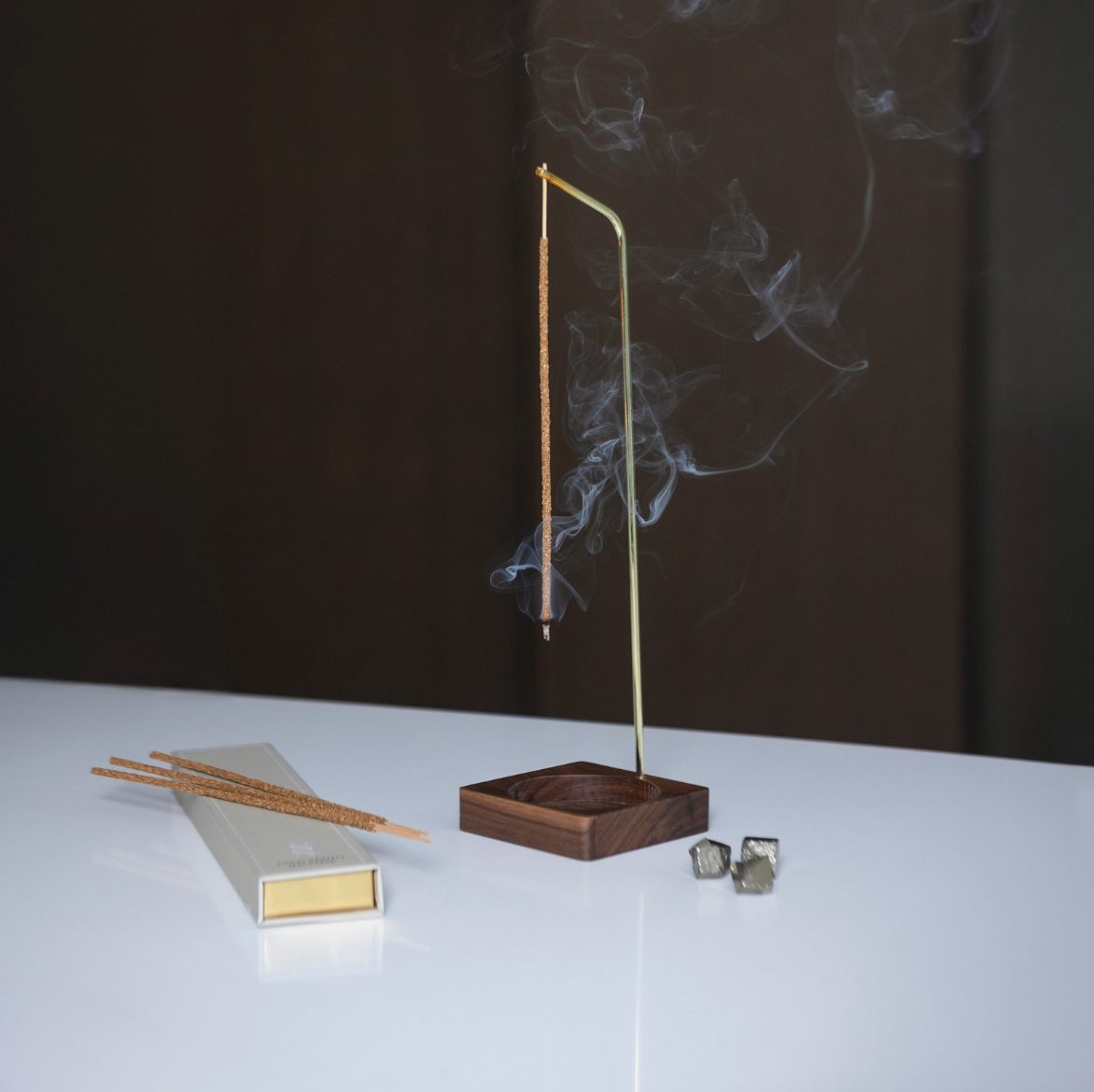 The burner in walnut with the incense box, shot against a dark ground