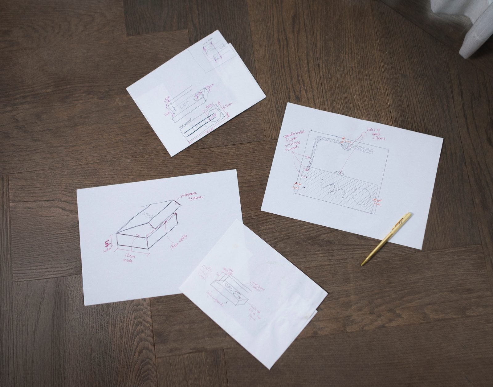 Original hand sketches for the burner and packaging, dimensioned in red
