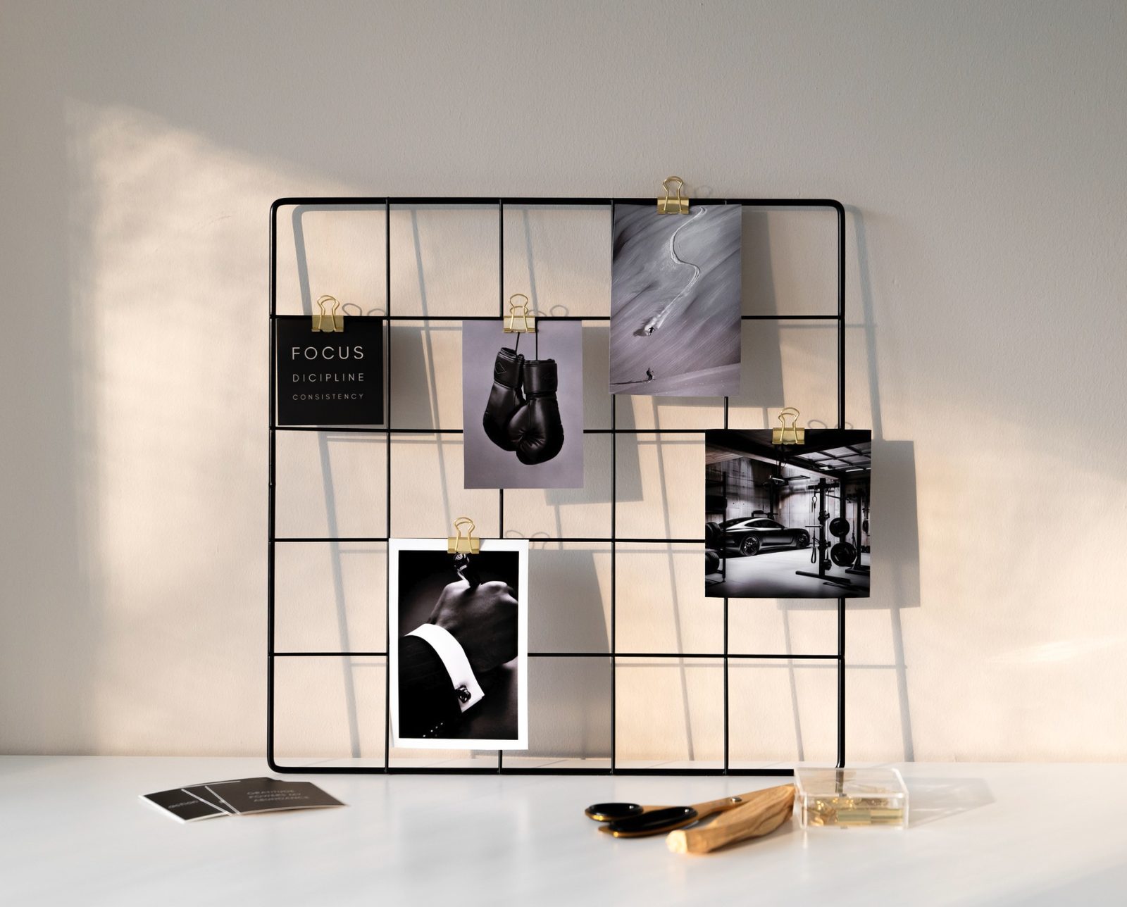 The vision board grid hung and styled with printed cards and gold clips