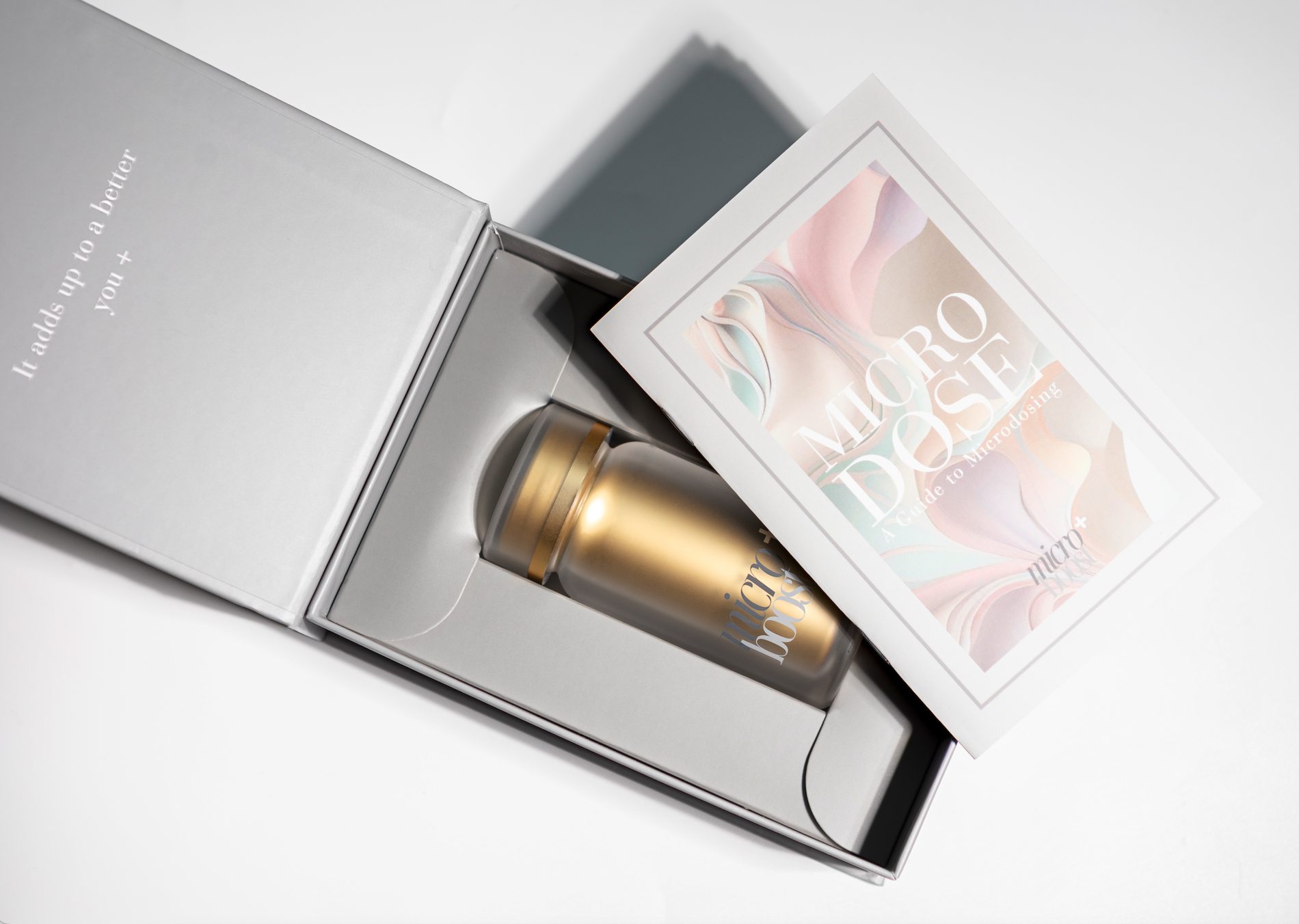 The gift box opened, bottle seated in its tray beside the printed guide, lid reading It adds up to a better you