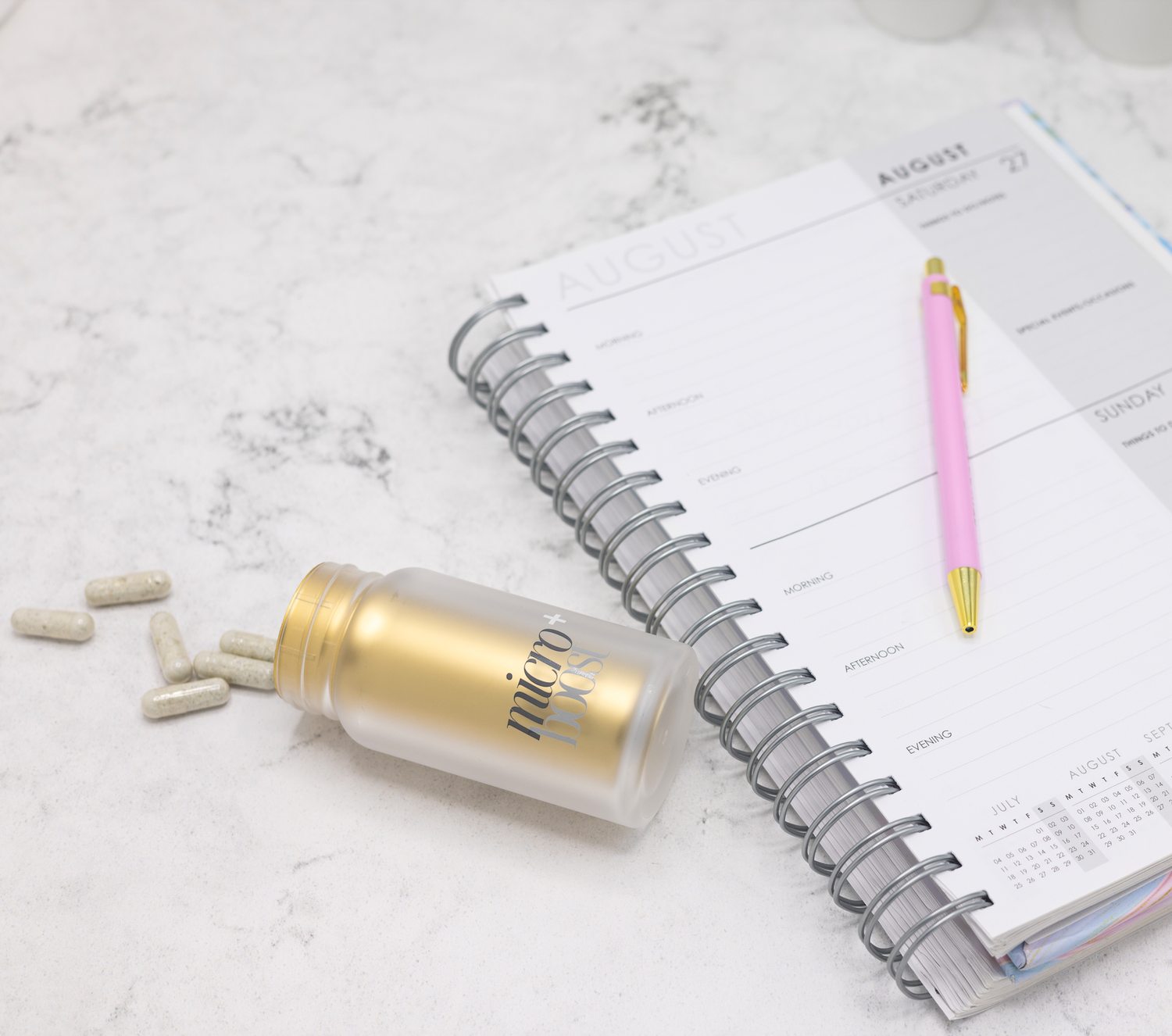 The bottle and capsules beside an open weekly planner